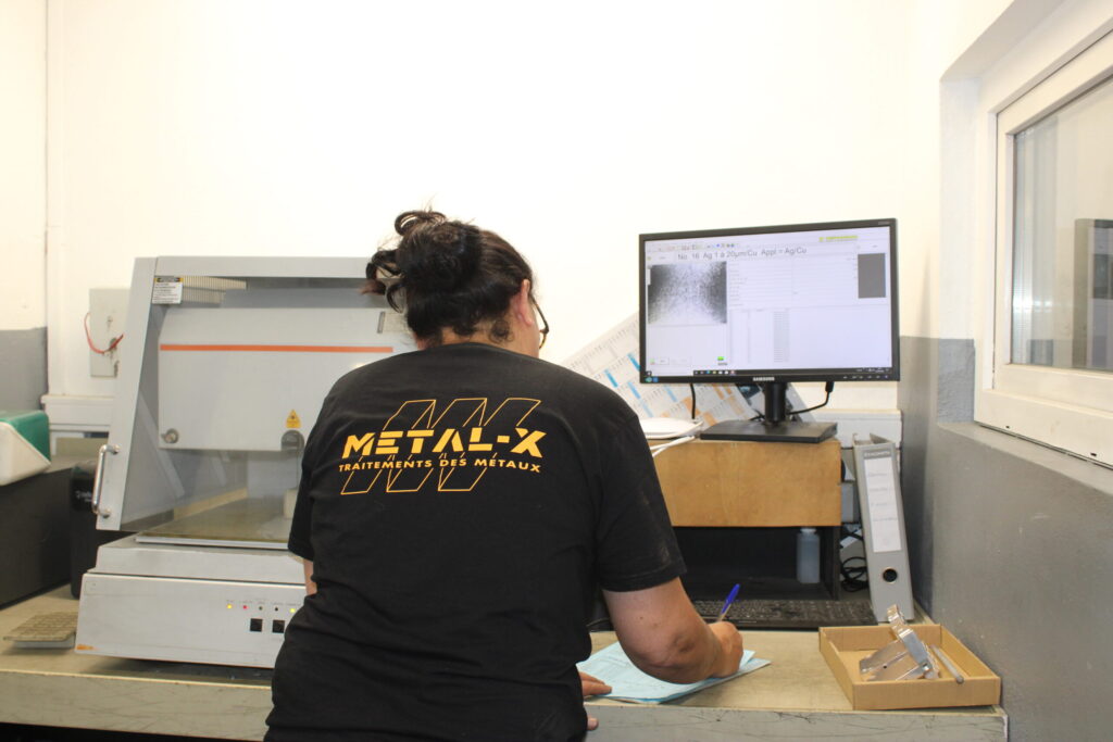 Technicien Metal-X à un poste de contrôle informatisé